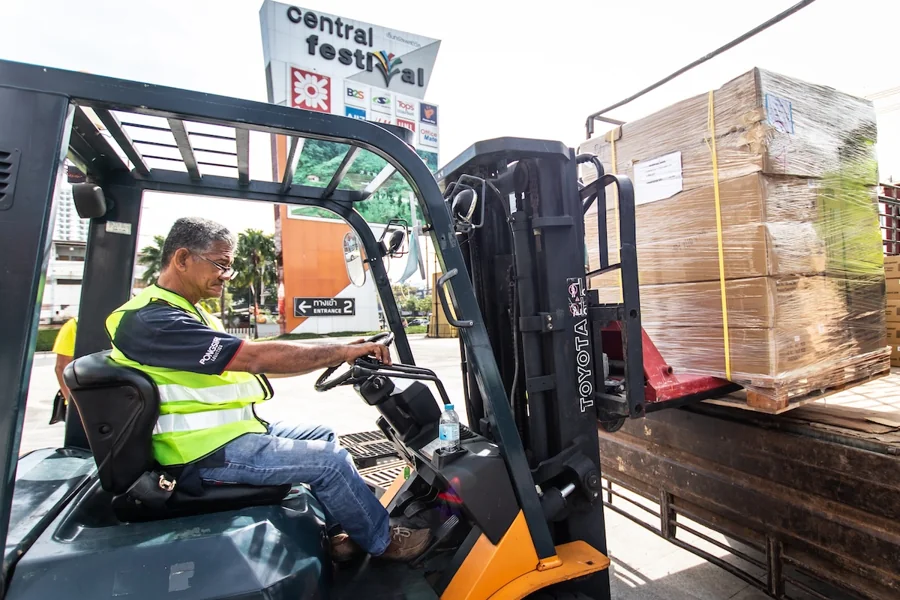 Pongsiri forklift operator loading wrapped palletized cargo