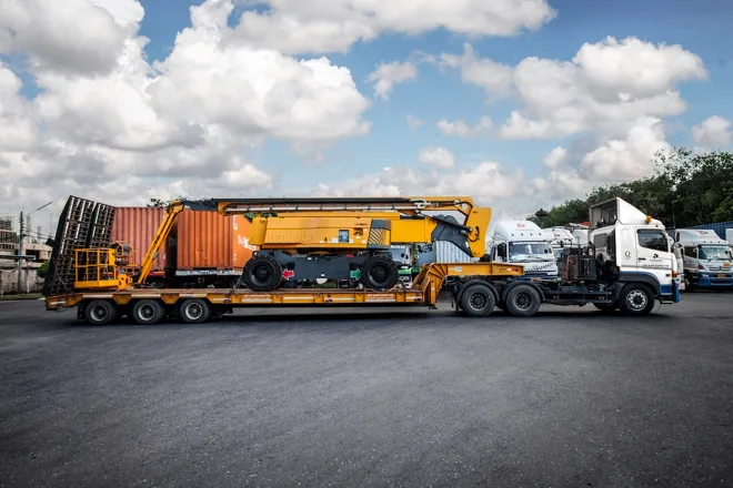 Long lowbed trailer carrying heavy machinery