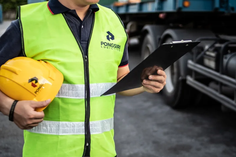 Pongsiri team member holding a safety helmet and inspection clipboard